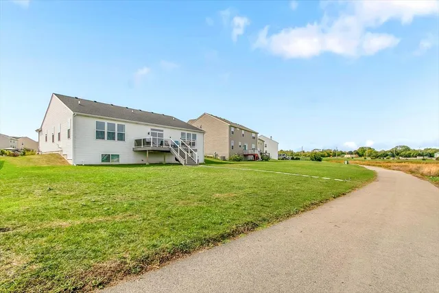 a view of a house with a big yard and large trees