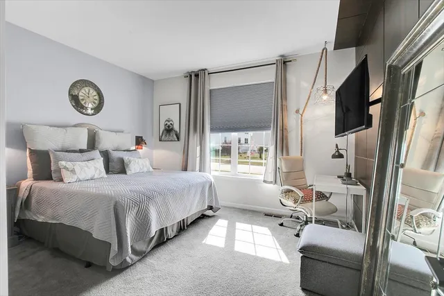 a bedroom with a bed couch and a window