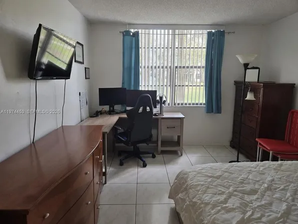 a reading room with furniture a flat screen tv and a window