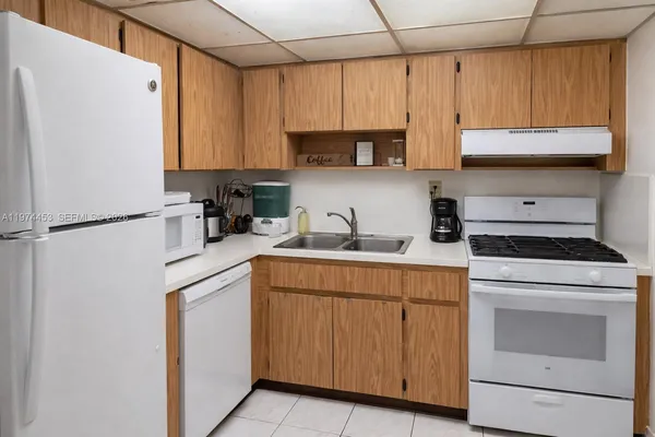 a kitchen with cabinets appliances a sink and a counter top space