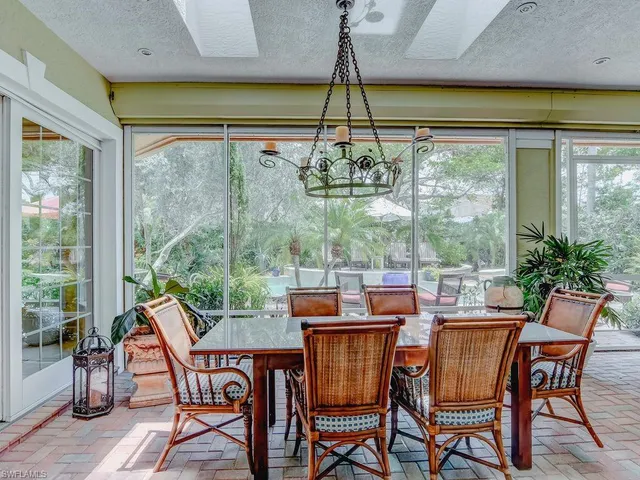 a dining room with furniture a chandelier and wooden floor