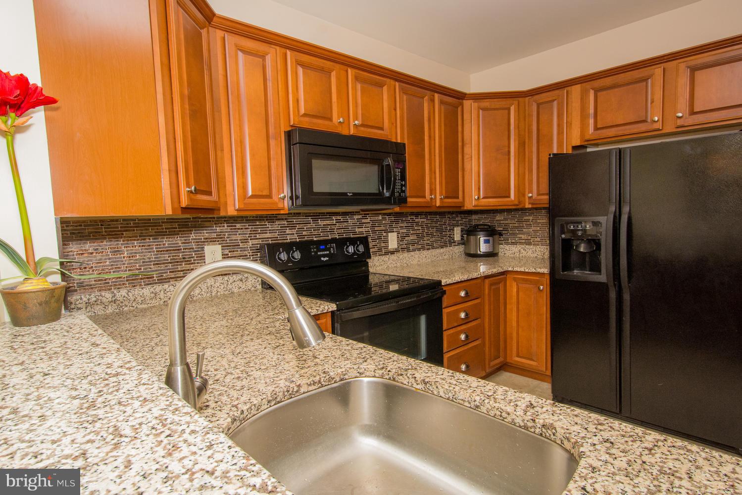 606 Moonglow Road, Unit 203 Odenton, MD 21113 - Photo 12 of 29 a kitchen with granite countertop a refrigerator stove and sink
