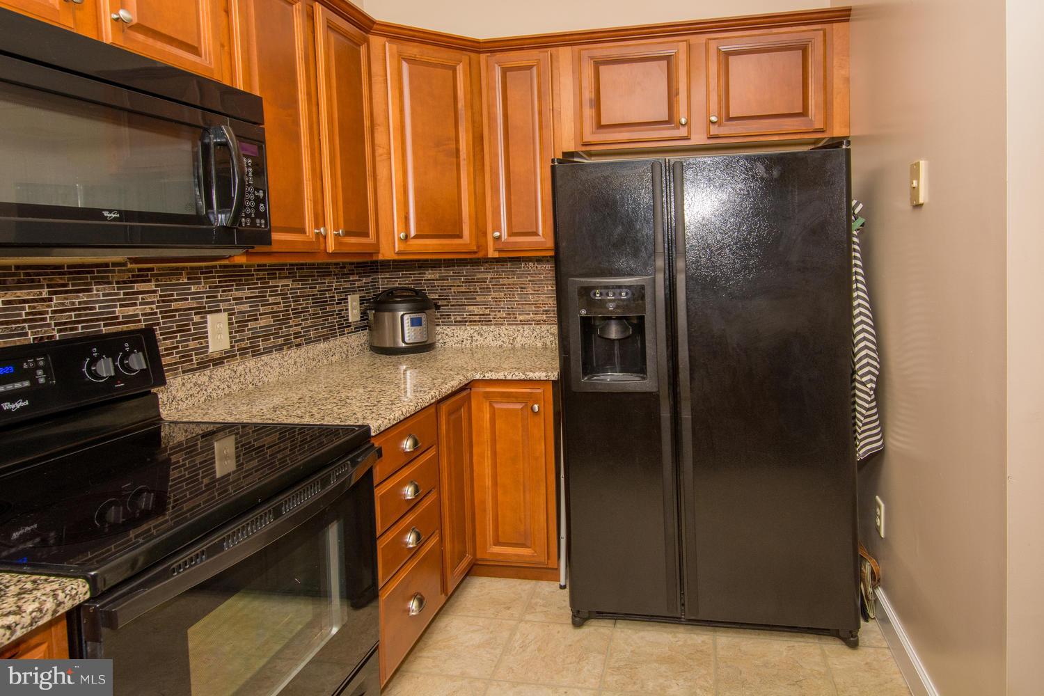 606 Moonglow Road, Unit 203 Odenton, MD 21113 - Photo 13 of 29 a kitchen with stainless steel appliances granite countertop a refrigerator and a stove top oven