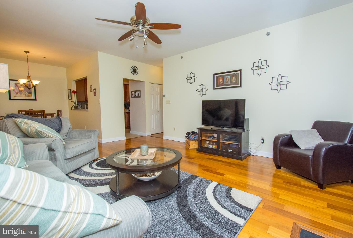 606 Moonglow Road, Unit 203 Odenton, MD 21113 - Photo 5 of 29 a living room with furniture a flat screen tv and kitchen view