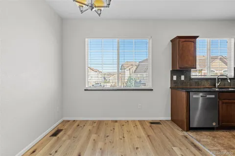 a view of kitchen with granite countertop cabinets and window