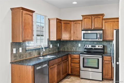 a kitchen with stainless steel appliances granite countertop a stove a sink and a microwave