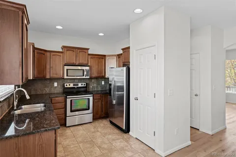 a kitchen with stainless steel appliances granite countertop a refrigerator stove and sink