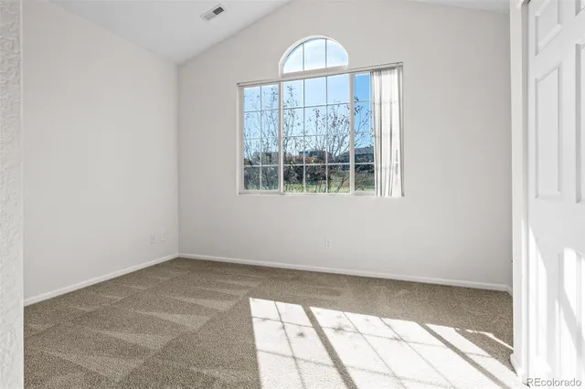 a view of a room that has a window and wooden floor