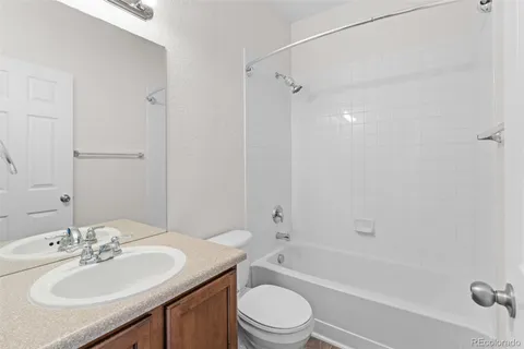a bathroom with a sink toilet tub vanity and shower