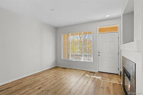 an empty room with wooden floor and a fireplace