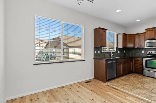 a kitchen with stainless steel appliances granite countertop a refrigerator stove and sink