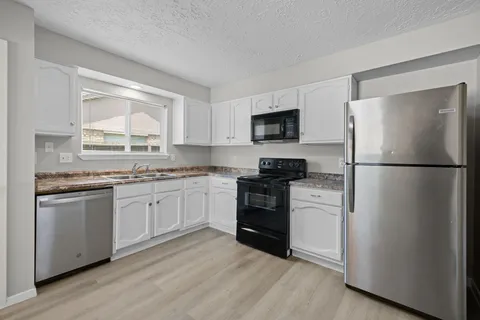a kitchen with a refrigerator stove and microwave