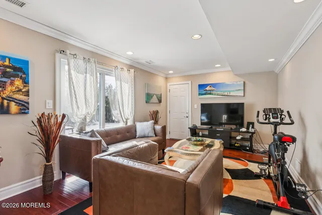 a living room with furniture a flat screen tv and a window