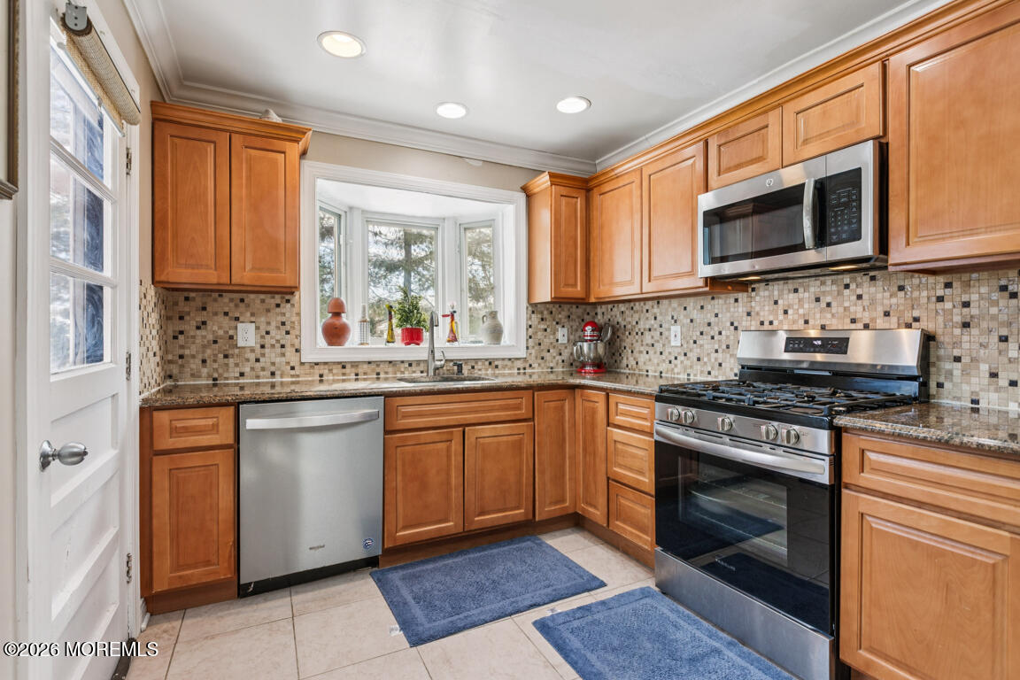 183 Pine Brook Road Manalapan, NJ 07726 - Photo 22 of 25 a kitchen with stainless steel appliances granite countertop a stove top oven microwave and sink