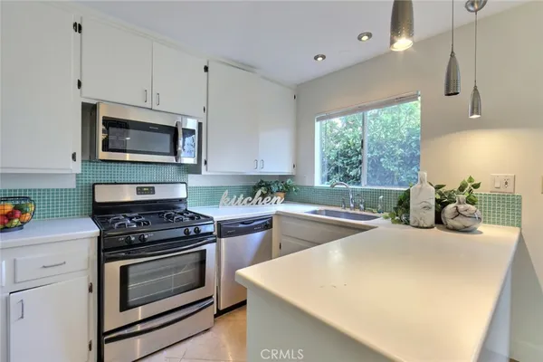 a kitchen with stainless steel appliances a stove sink microwave and cabinets