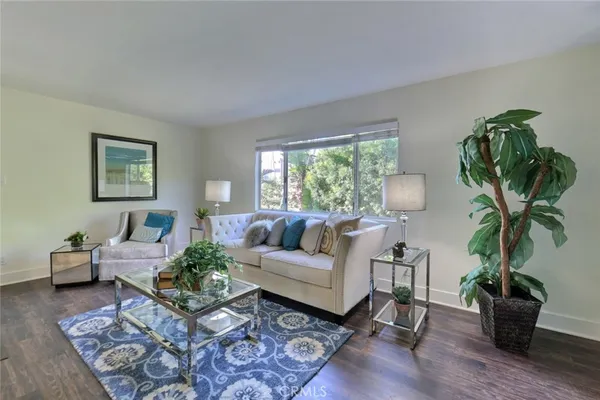 a living room with furniture a potted plant and a window