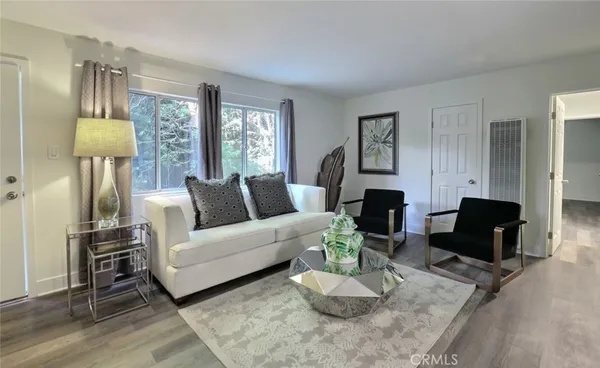 a living room with furniture a lamp wooden floor and a fireplace
