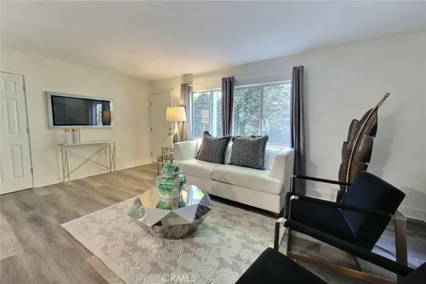 a living room with furniture a flat screen tv and a large window