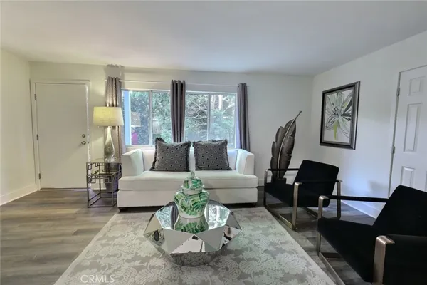 a living room with furniture and wooden floor