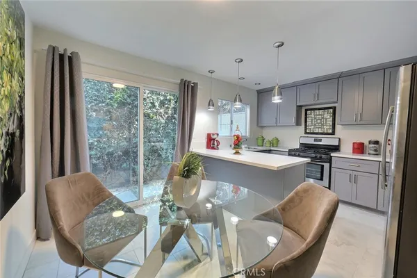 a living room with stainless steel appliances granite countertop furniture and a large window