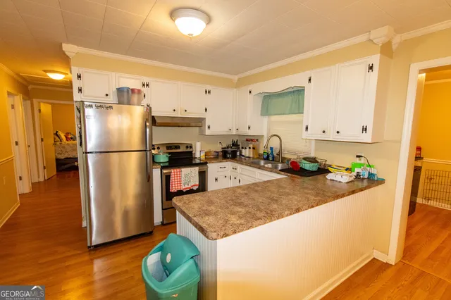 a kitchen with stainless steel appliances granite countertop a refrigerator a stove and a sink