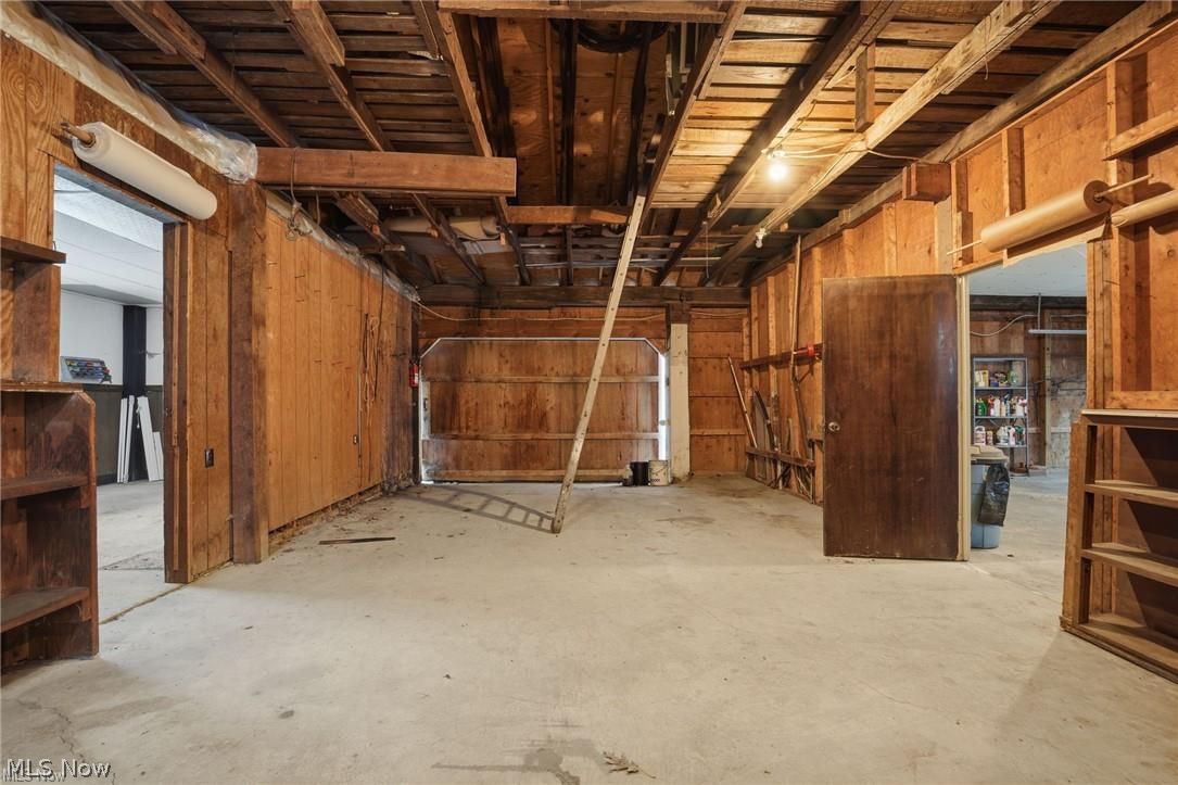 17452 Huntley Road Windsor, OH 44099 - Photo 44 of 49 Misc room featuring wood walls, unfinished concrete floors, and a garage
