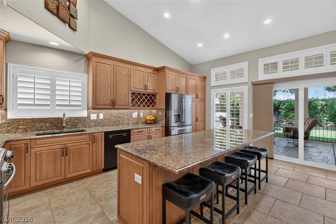 818 Manor Shores Road Henderson, NV 89002 - Photo 17 of 35 Culinary adventures await in this kitchen featuring abundant wood cabinetry and granite countertops with a spacious island.