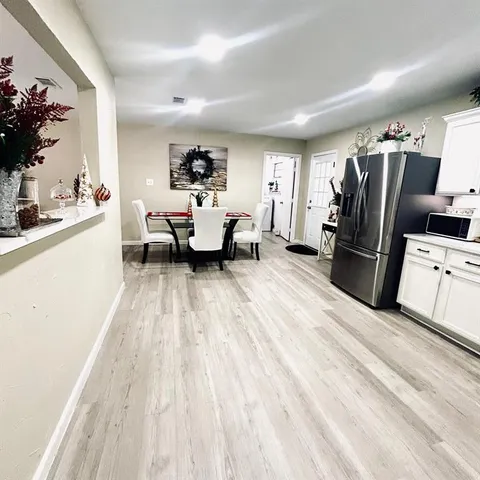 a kitchen view with stainless steel appliances wooden floor and a refrigerator