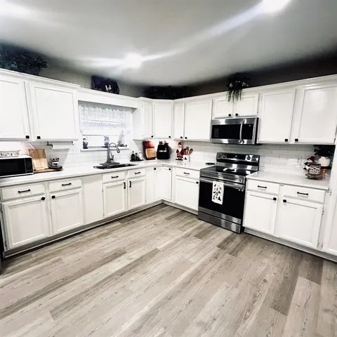 a kitchen with stainless steel appliances granite countertop a stove sink and cabinets