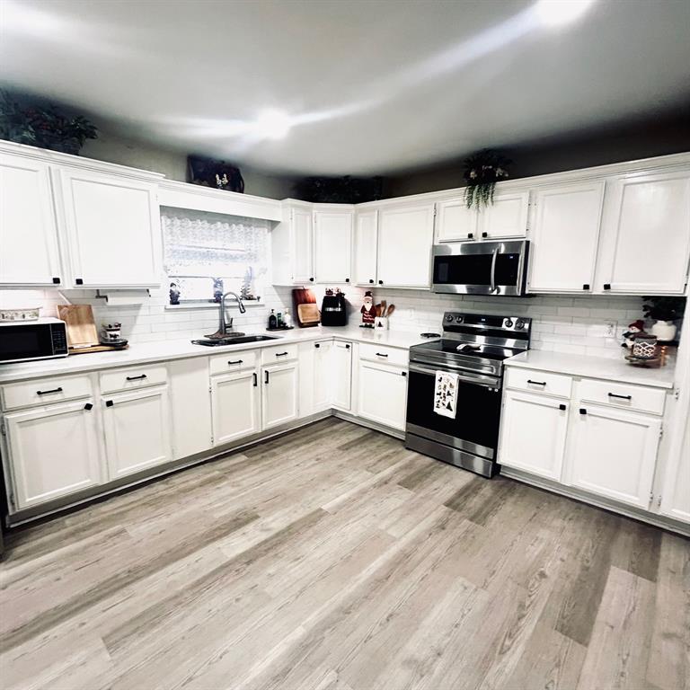 307 East 5th Street Kaufman, TX 75142 - Photo 12 of 27 a kitchen with stainless steel appliances granite countertop a stove sink and cabinets