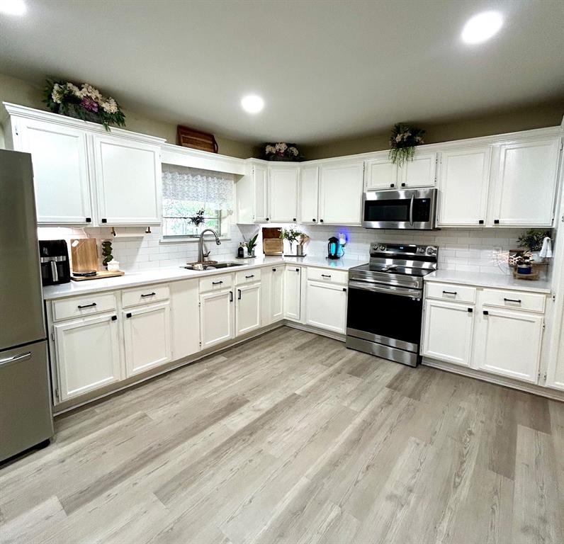 307 East 5th Street Kaufman, TX 75142 - Photo 13 of 27 a kitchen with stainless steel appliances granite countertop a sink a stove a refrigerator cabinets and a microwave