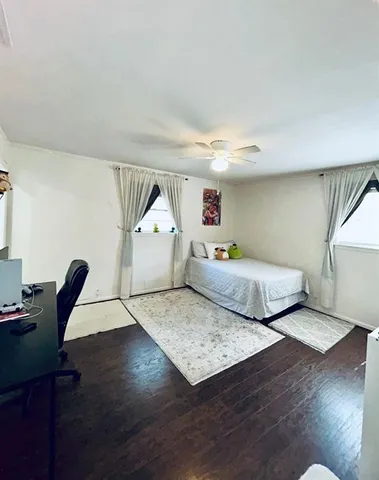 a bedroom with furniture and a wooden floor