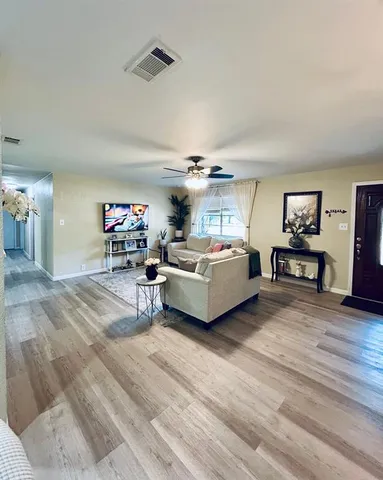 a living room with furniture and a wooden floor