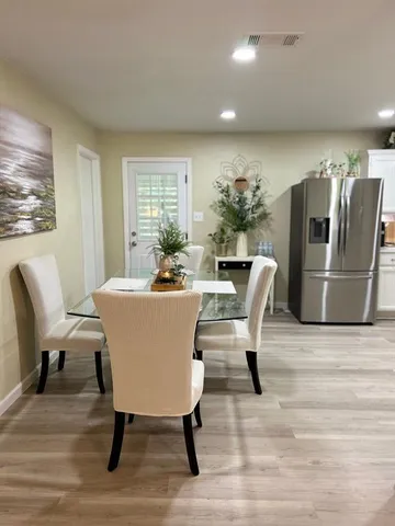 a dining room with furniture and wooden floor
