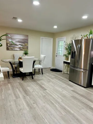 a kitchen with stainless steel appliances wooden floor and a refrigerator