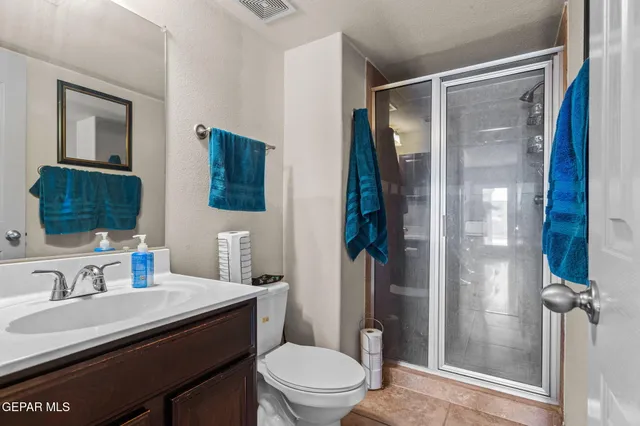 a bathroom with a granite countertop sink toilet and shower