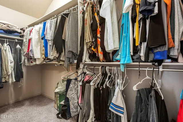 a view of walk in closet with clothes and shoes