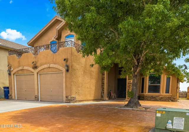 a view of a white house with a large tree
