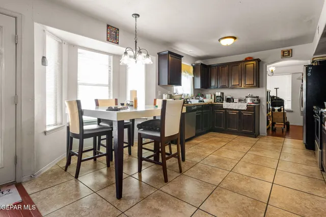 a kitchen with stainless steel appliances granite countertop a stove a sink a dining table and chairs
