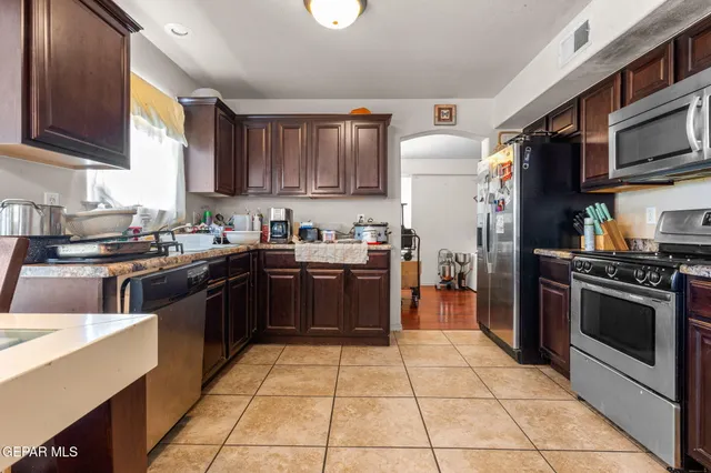 a kitchen with stainless steel appliances granite countertop a stove a sink dishwasher and a refrigerator