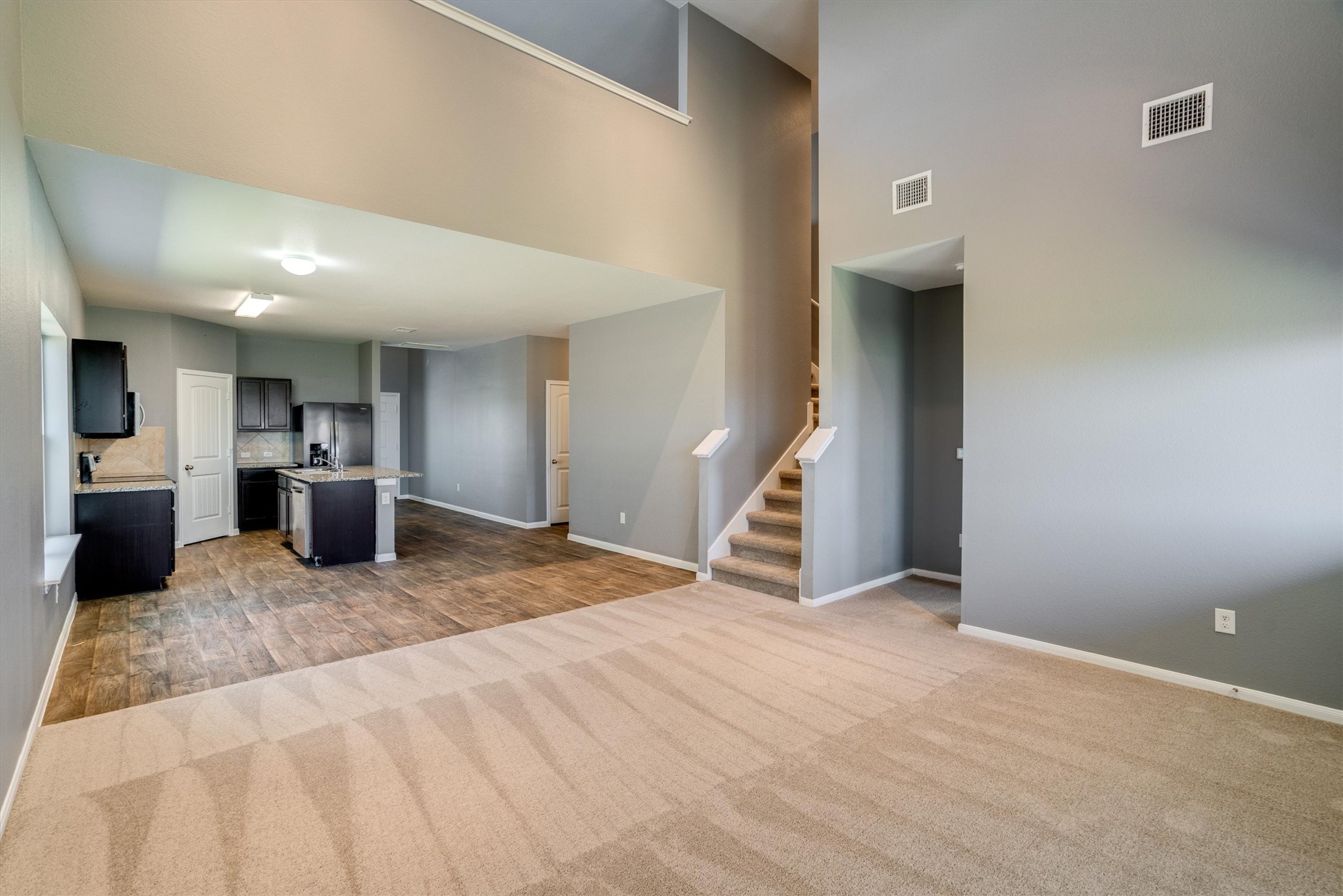 15128 Shell Bark Cove Austin, TX 78724 - Photo 6 of 25 An open-concept living space with a modern kitchen and convenient stairway access.