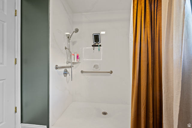 555 East 1700 N Street Mapleton, UT 84664 - Photo 29 of 49 White shower stall featuring a built-in shelf, grab bars, and a handheld showerhead