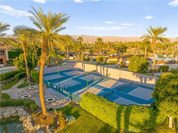a view of a swimming pool with a lawn chairs under an umbrella
