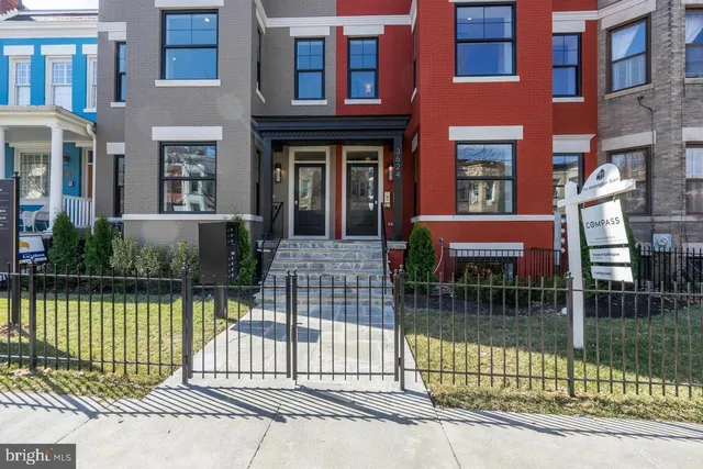 a front view of a house with a garden and plants