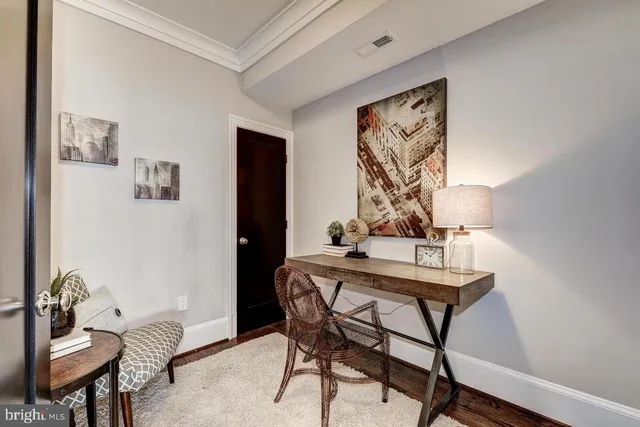 a view of a workspace room with furniture and wooden floor