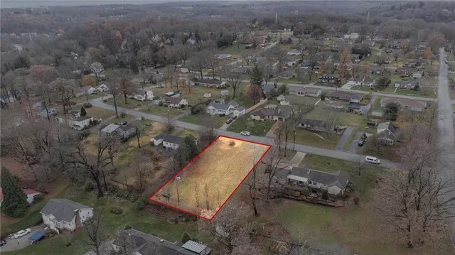 an aerial view of a house with a yard and tree s