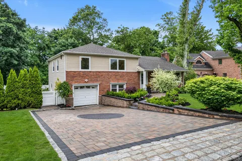 a front view of a house with a yard and a garage