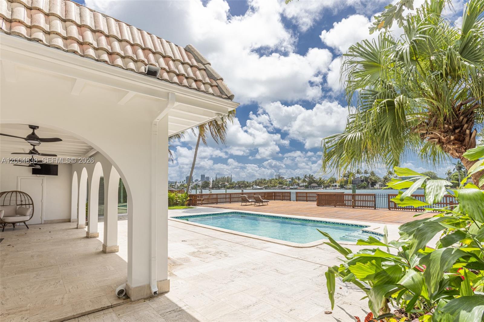 1690 Daytonia Road Miami Beach, FL 33141 - Photo 61 of 88 a view of a swimming pool with a lawn chairs and potted plants