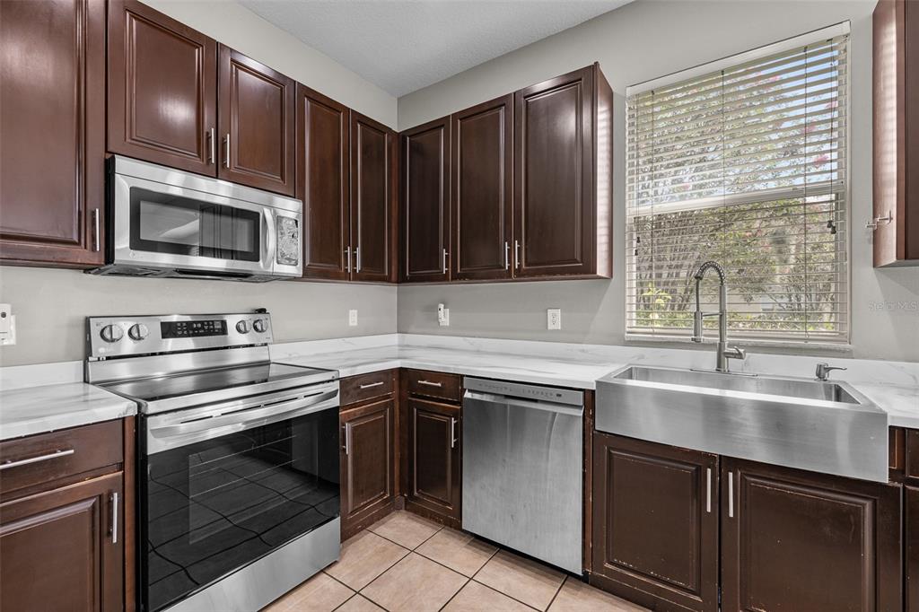 5909 Wedgefield Drive Zephyrhills, FL 33541 - Photo 13 of 54 a kitchen with cabinets stainless steel appliances and sink
