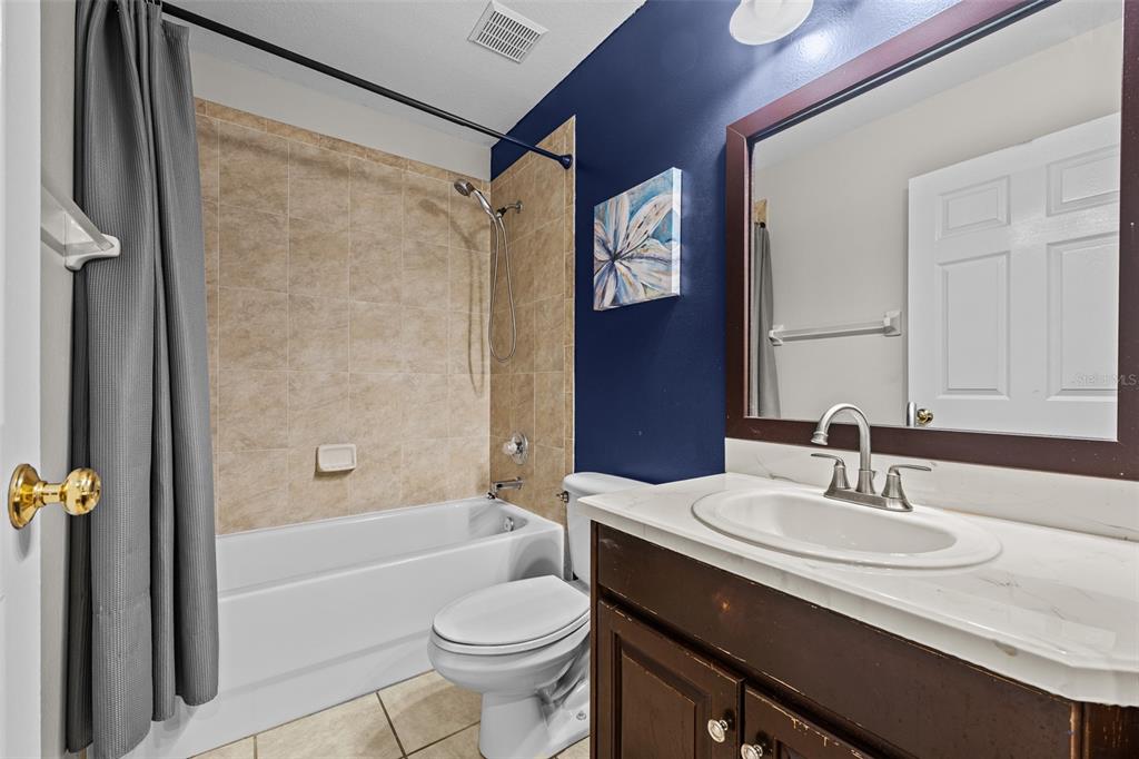 5909 Wedgefield Drive Zephyrhills, FL 33541 - Photo 21 of 54 a bathroom with a granite countertop sink toilet and shower